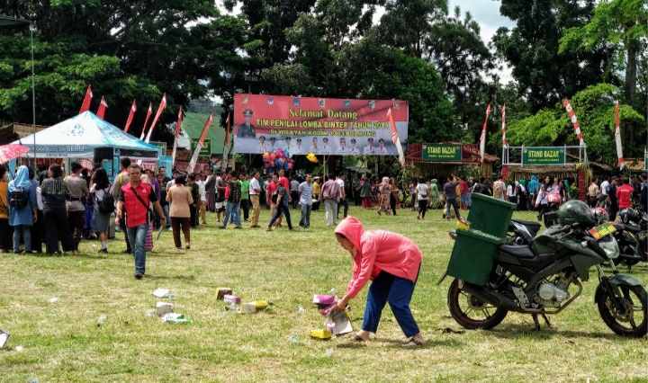 Petugas Kebersihan Ini Tetap Jalankan Tugasnya Meski Riuh dengan Acara