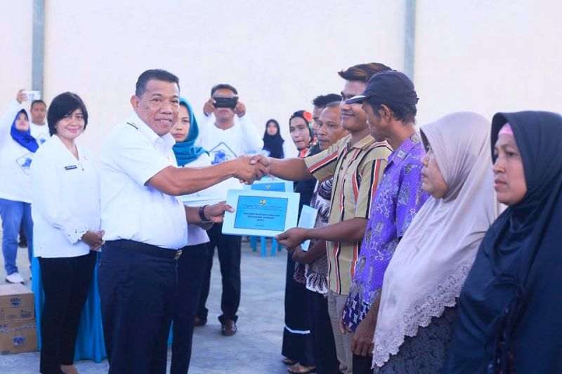 Bupati Bolmut Menyerahkan Sekaligus Memasang Peneng Rumah Program BSPS