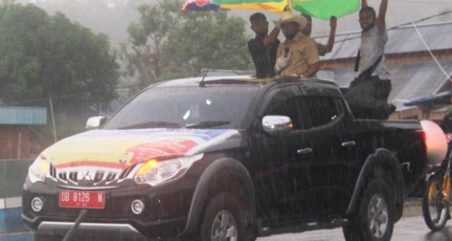 Diguyur Hujan, Bupati Boltim Tetap Semangat Sosialisasikan Perang Terhadap Covid-19