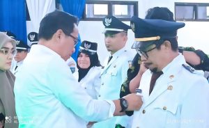 Bupati Boltim memasangkan pin jabatan kepada Pjs Sangadi
